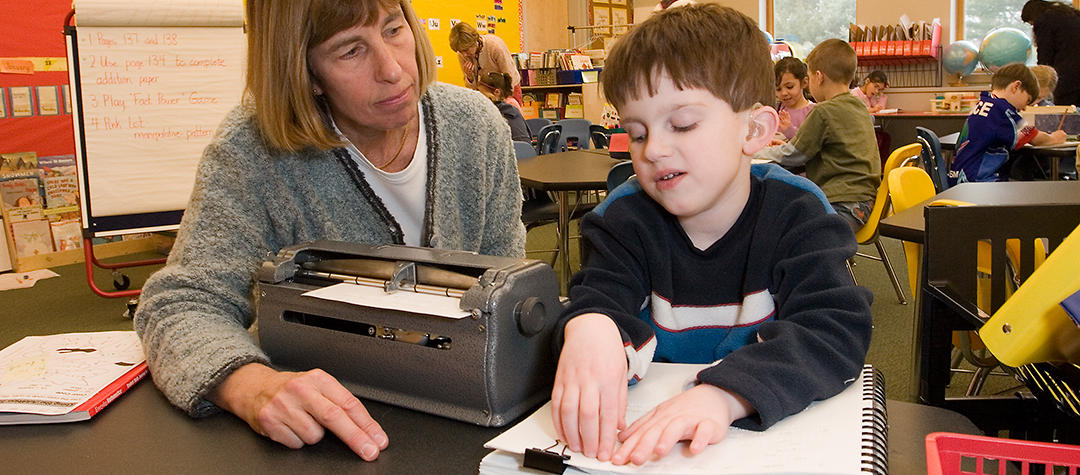 a teacher and student during a braille lesson